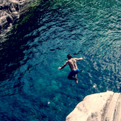 Man jumping into water from cliffside