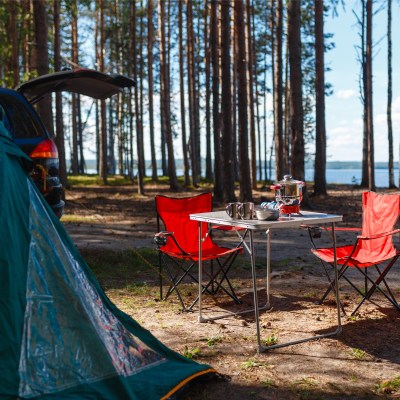 Camping gear by lake and trees