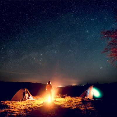 Campground at night with fire and stars