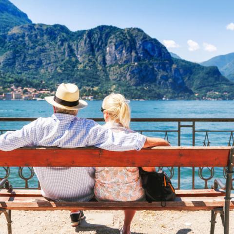a person sitting on a bench in front of a body of water