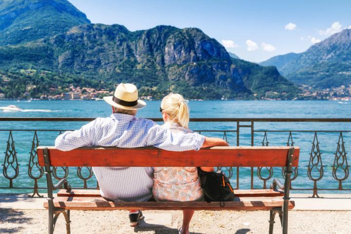 a person sitting on a bench in front of a body of water