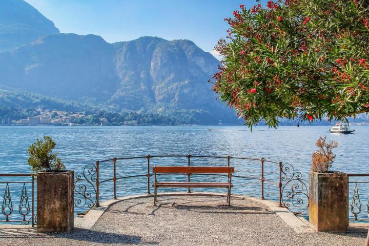 a bench next to a body of water with a mountain in the background