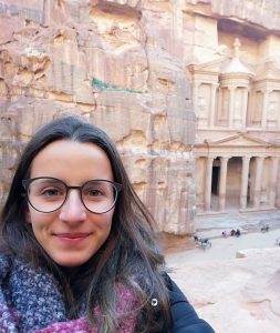 a girl wearing glasses and smiling at the camera