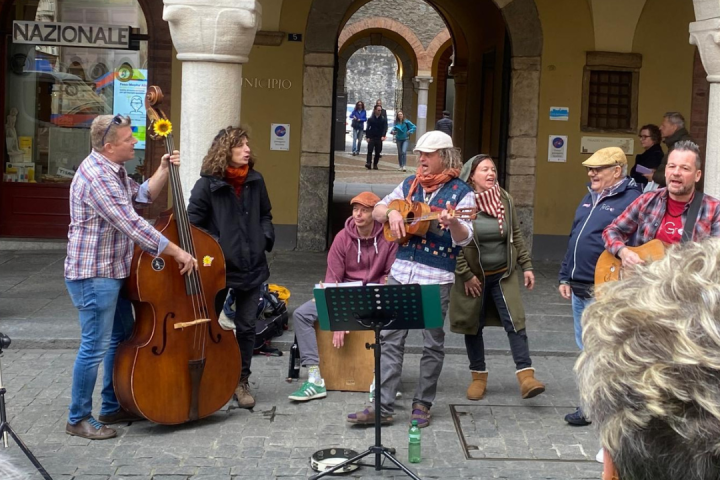 Street musicians playing instruments and performing for a small crowd.