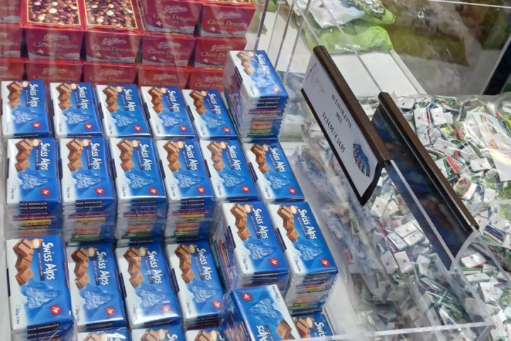 Boxes of Swiss Alps chocolates displayed in a store along with other candy.